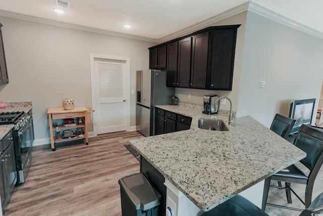 949 Jackline Pl Unit 103, Murrells Inlet, SC 29576 - kitchen with black gas stove, a sink, a kitchen bar, light stone counters, and a peninsula
