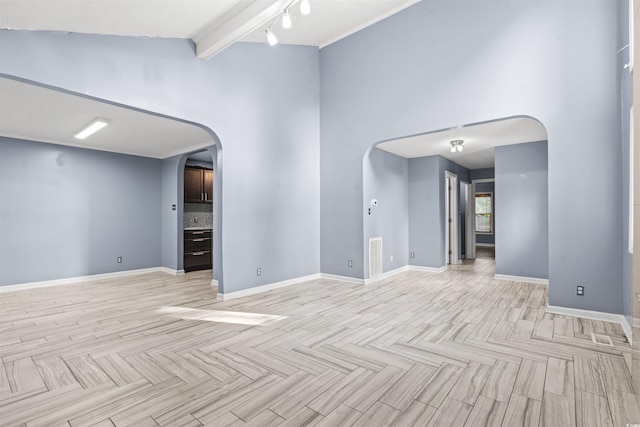 empty room with beam ceiling and high vaulted ceiling