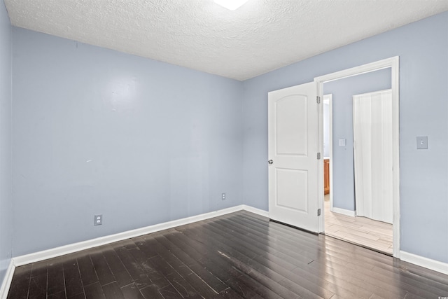 interior space featuring a textured ceiling and dark wood-type flooring