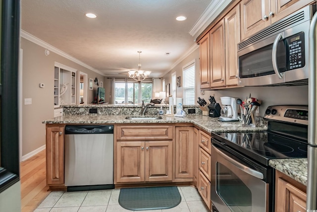 kitchen featuring crown molding, an inviting chandelier, a peninsula, appliances with stainless steel finishes, and a sink