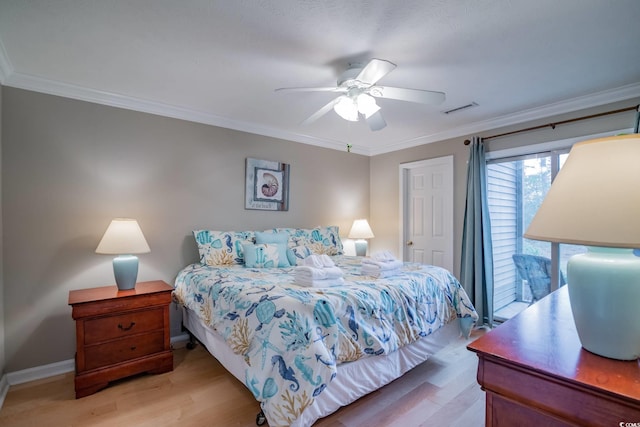 bedroom featuring baseboards, visible vents, light wood-type flooring, and crown molding