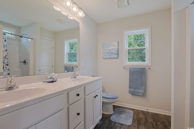 bathroom featuring walk in shower, vanity, toilet, and hardwood / wood-style flooring