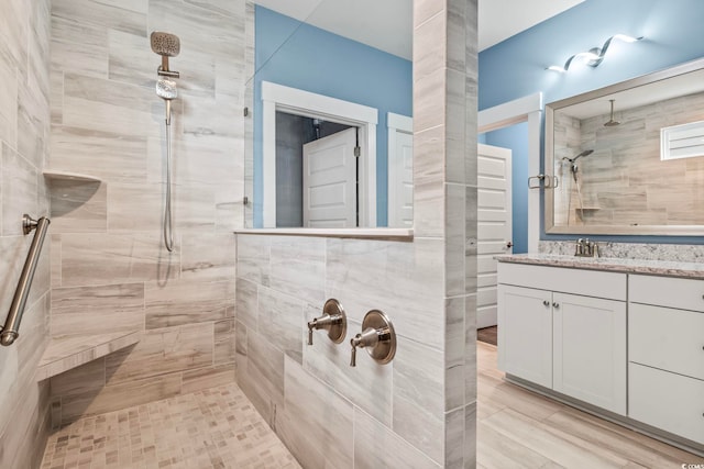 bathroom featuring vanity and tiled shower