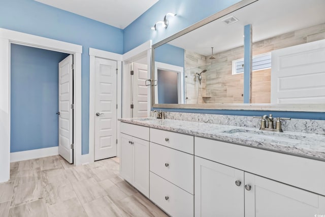 bathroom featuring visible vents, a sink, double vanity, and tiled shower