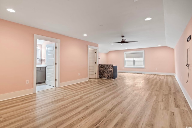 unfurnished living room with light hardwood / wood-style flooring, vaulted ceiling, and ceiling fan