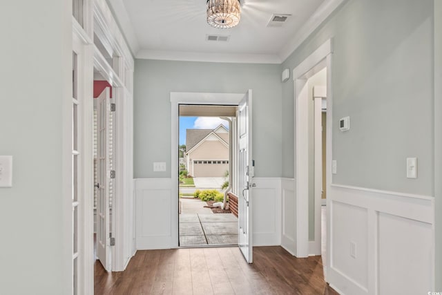 entrance foyer featuring ornamental molding and dark hardwood / wood-style flooring