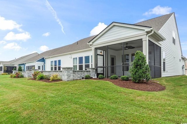 rear view of property featuring a lawn, roof with shingles, ceiling fan, and a sunroom