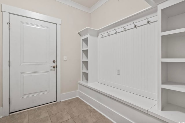 mudroom featuring crown molding, baseboards, and light tile patterned floors