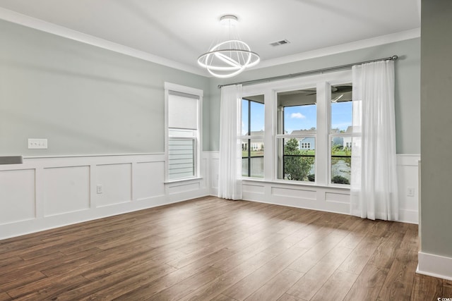 empty room featuring a chandelier, visible vents, wainscoting, and dark wood-type flooring
