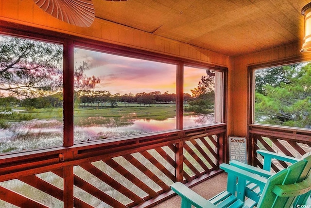 unfurnished sunroom featuring wooden ceiling and a water view