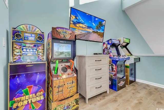 recreation room with light hardwood / wood-style flooring and vaulted ceiling