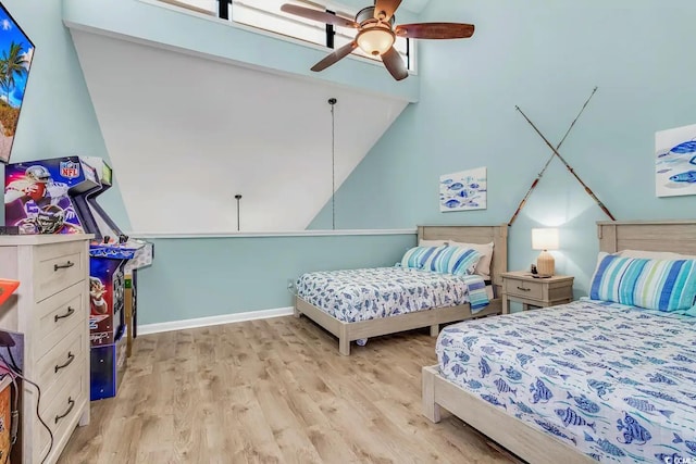 bedroom with light hardwood / wood-style flooring, vaulted ceiling, and ceiling fan