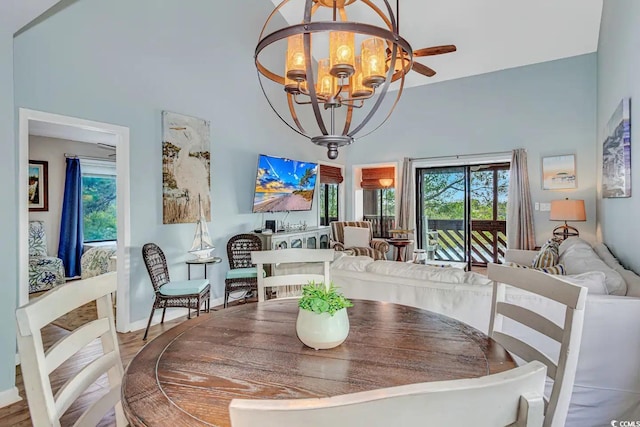 dining space with ceiling fan with notable chandelier and hardwood / wood-style floors