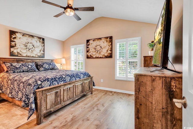 bedroom featuring light wood-type flooring, vaulted ceiling, multiple windows, and ceiling fan