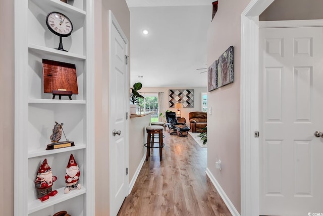 hall with light wood-type flooring and built in features