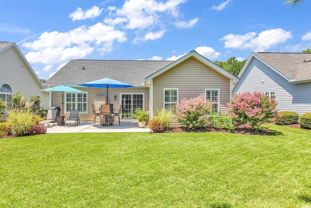 back of house with a lawn and a patio