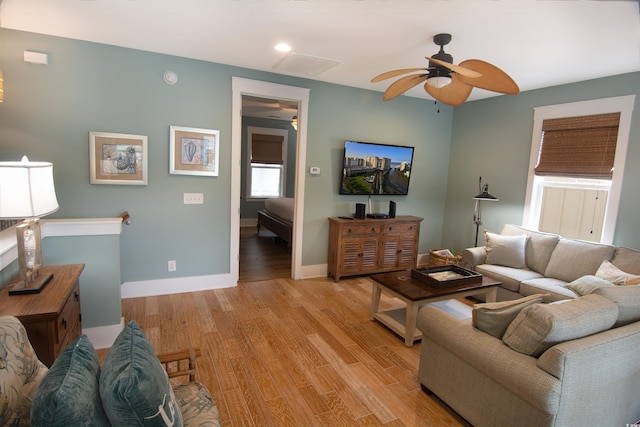 living room with light wood-type flooring and ceiling fan