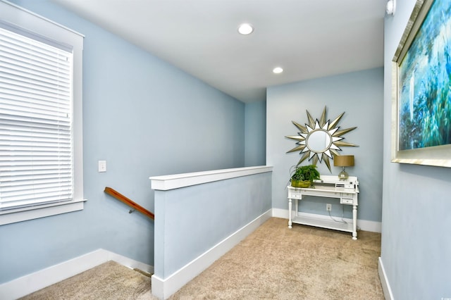 hallway featuring a wealth of natural light and light colored carpet