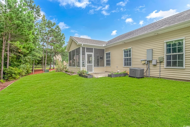 rear view of property with a yard, cooling unit, and a sunroom