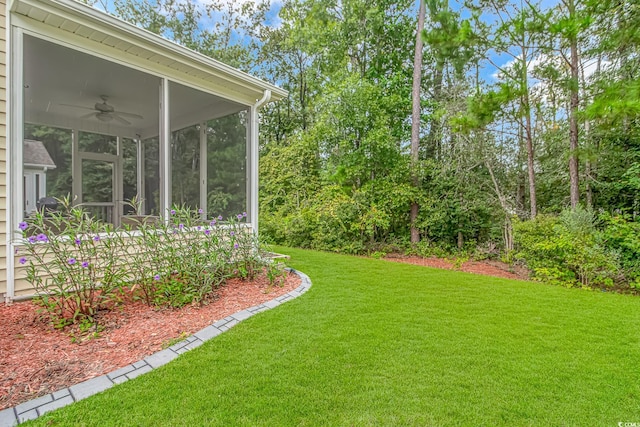 view of yard with a sunroom and ceiling fan