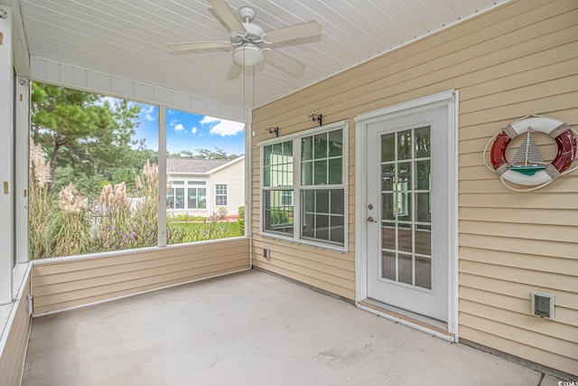 unfurnished sunroom featuring ceiling fan