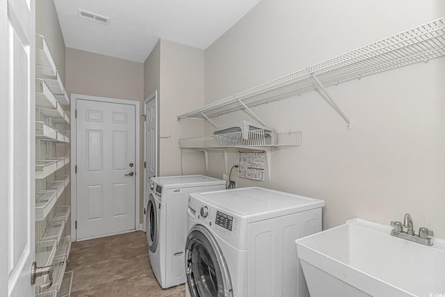 laundry area featuring washing machine and dryer and sink