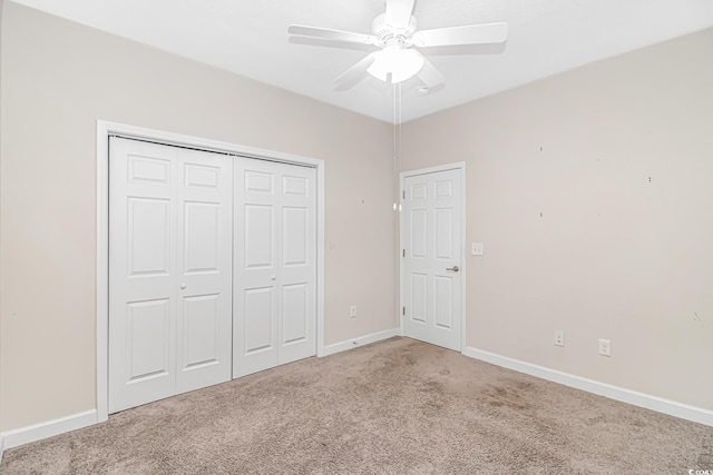 unfurnished bedroom featuring ceiling fan, a closet, and light colored carpet