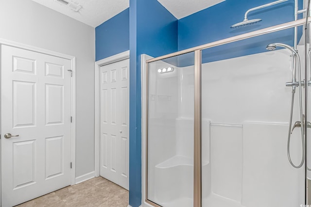 bathroom featuring a textured ceiling and walk in shower