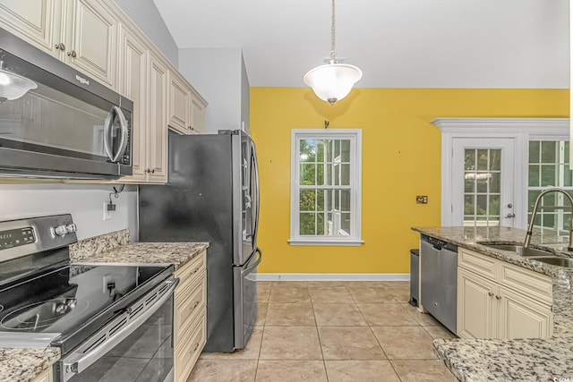 kitchen featuring sink, stainless steel appliances, decorative light fixtures, and cream cabinetry