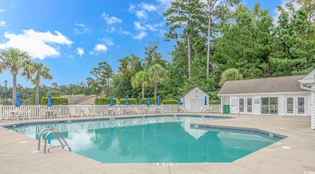 view of swimming pool with an outdoor structure and a patio