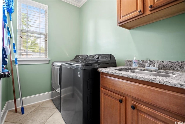 washroom with cabinets, a wealth of natural light, ornamental molding, and separate washer and dryer