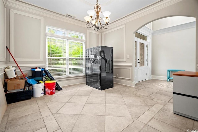 interior space with ornamental molding and an inviting chandelier