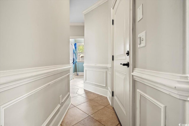 hall with light tile patterned flooring and crown molding