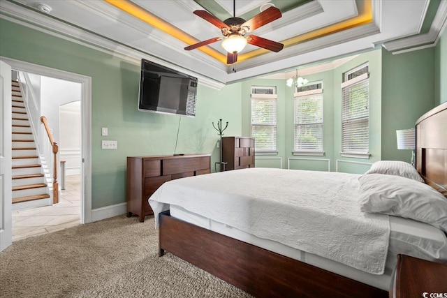 carpeted bedroom with ceiling fan, a tray ceiling, and crown molding