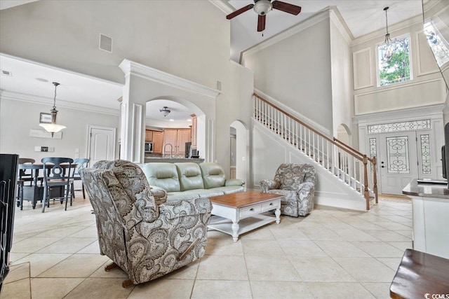 living room featuring ornamental molding, a high ceiling, ceiling fan, and light tile patterned floors