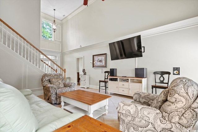 living room with a high ceiling, ornamental molding, ceiling fan, and light tile patterned flooring