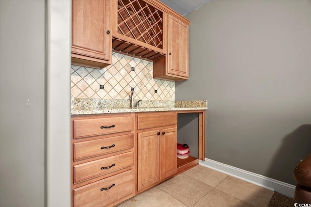 kitchen with light stone countertops, light tile patterned floors, and tasteful backsplash