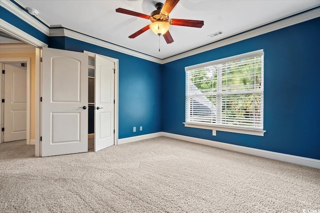 carpeted empty room with ornamental molding and ceiling fan