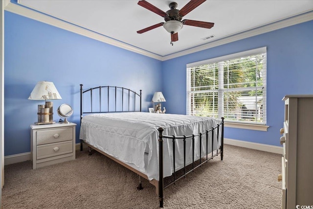 carpeted bedroom with ornamental molding and ceiling fan