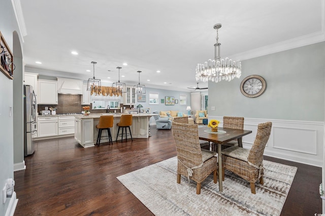 dining room featuring a notable chandelier, sink, dark hardwood / wood-style floors, and crown molding