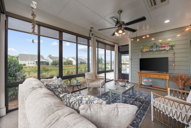 living room featuring ceiling fan and wood walls