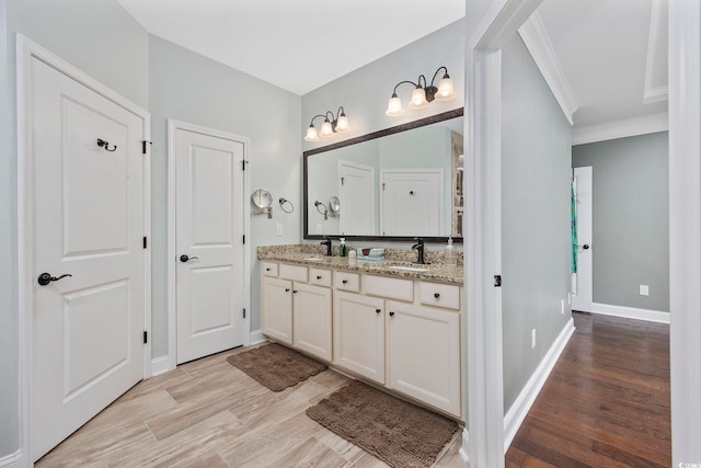 bathroom featuring ornamental molding, hardwood / wood-style flooring, and vanity