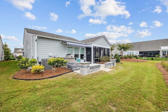 back of house featuring a patio, a yard, a sunroom, and central AC