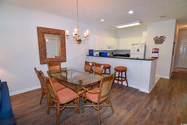 dining room featuring a textured ceiling, dark hardwood / wood-style floors, and a notable chandelier