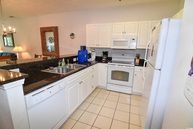 kitchen featuring sink, white cabinetry, hanging light fixtures, an inviting chandelier, and white appliances