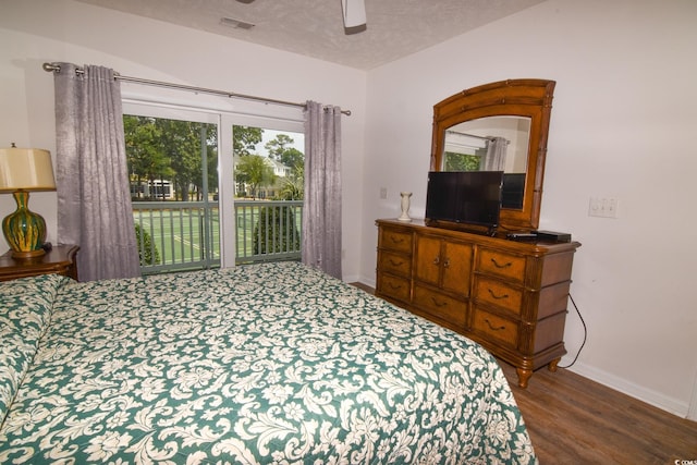 bedroom with access to outside, a textured ceiling, dark hardwood / wood-style floors, and ceiling fan