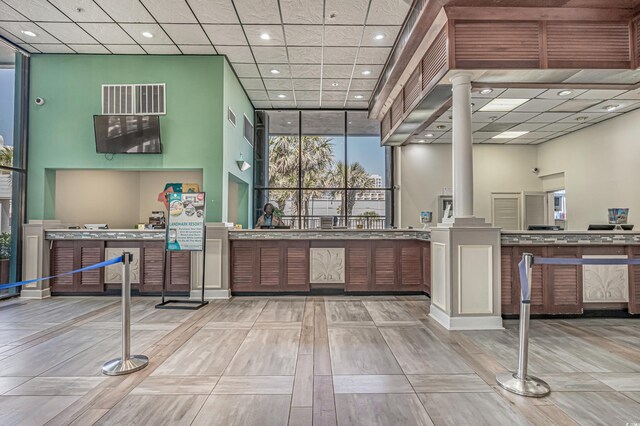 kitchen with light hardwood / wood-style floors, a towering ceiling, and ornate columns