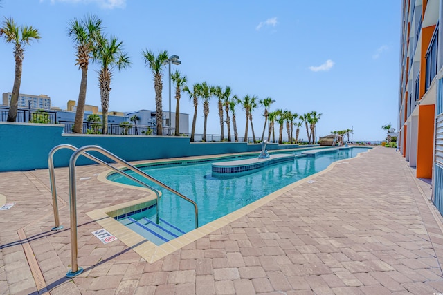 view of swimming pool with a patio area and a hot tub