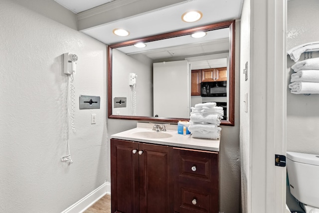 bathroom with vanity, hardwood / wood-style floors, and toilet