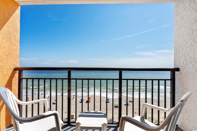 balcony featuring a water view and a beach view